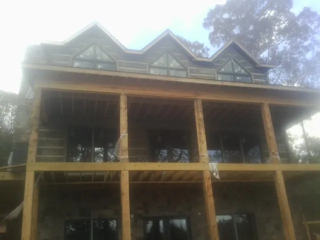 Dormers and porch framing on a large log home under construction — Roof Coating work by our crew in Cottondale